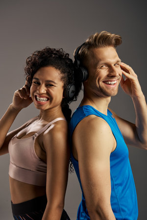 A young multicultural couple in active wear smiling while wearing headphones.の写真素材