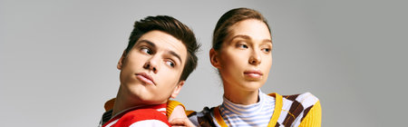 Attractive male and female students in casual attire standing next to each other in a college...