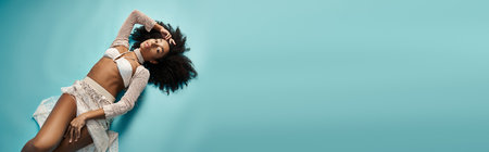 African American woman in trendy swimsuit relaxes on blue background.
