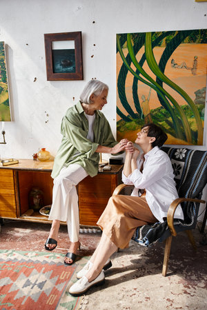 A mature lesbian couple sit in an intimate moment.の写真素材