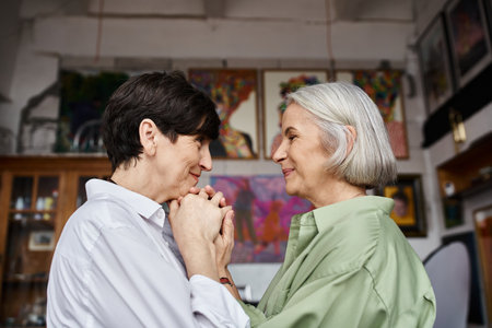 A mature lesbian couple standing together in an art studio.の写真素材