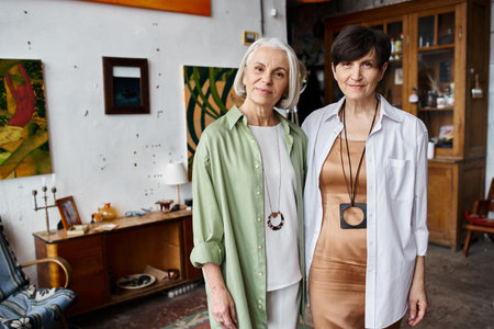 Mature lesbian couple standing in art studio together.の写真素材