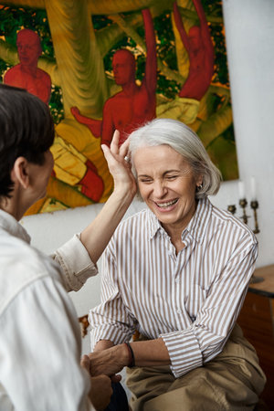 Two women sit before artwork in art studio.の写真素材