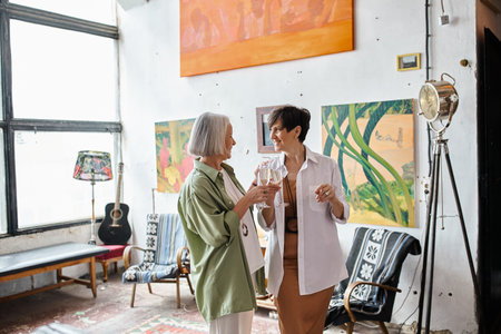 Mature lesbian couple standing in art studio.の写真素材