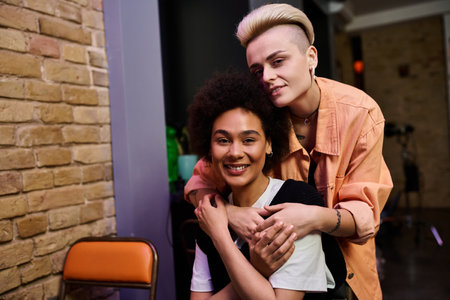 Woman passionately hugs her female partner in front of brick wall.の写真素材