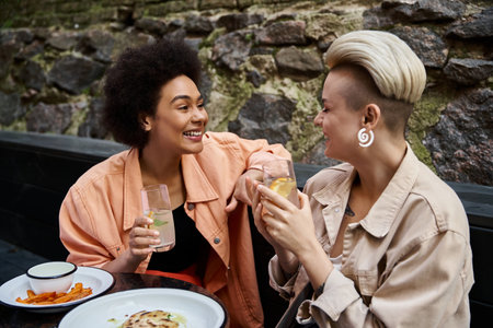 A diverse couple of women enjoying a meal together at a table in a cafe.の写真素材