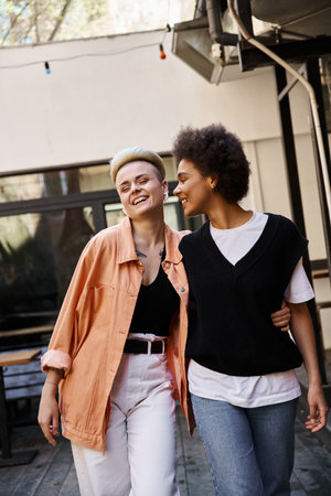 Two women walk together down a city street.の写真素材