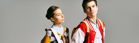 A stylish male and female students stand confidently in a college classroom.
