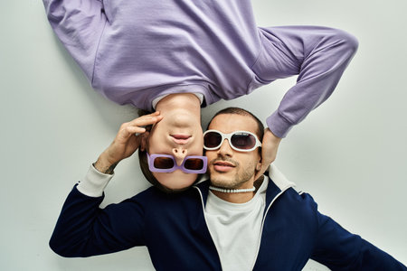 two men intertwined, laying atop each other in a close embrace.