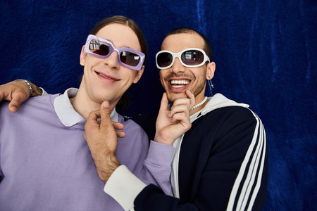 Two stylish men standing close together, enjoying each others company.