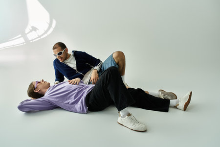 An attractive gay couple laying on the ground, sharing quality time together.