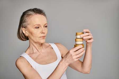 A woman gazes upon a tall stack of cream jars.の写真素材