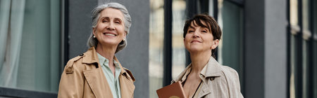 A mature, beautiful lesbian couple taking a walk to their office together.の写真素材