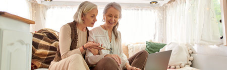 A lesbian couple enjoys a moment of togetherness while on a road trip in their camper van.