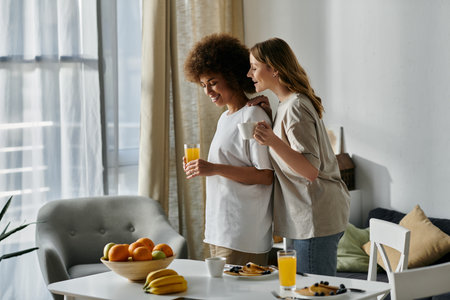 Two women in casual attire enjoy a morning together in their home.の写真素材
