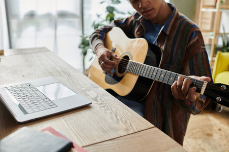 A man serenades with an acoustic guitar in front of a phone.の写真素材