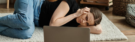 Middle-aged woman lying next to laptop, deep in thought.