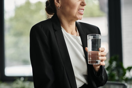 A businesswoman in her office holding a glass of water.の写真素材