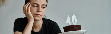 A woman joyfully holding a cake with a 40 candle on it.