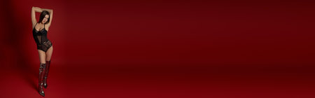 Stylish woman in lingerie and boots posing confidently.の写真素材