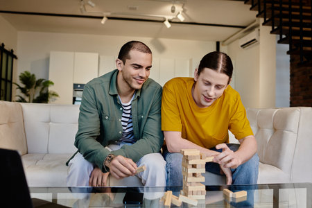 A young gay couple enjoys a relaxed evening at home, playing a game of blocks and laughing together...