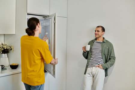 A young gay couple in casual attire enjoys a quiet morning in their modern apartment.の写真素材