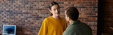 A young gay couple in casual attire spends quality time together in their modern apartment.の写真素材