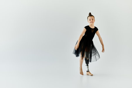 A young girl with a prosthetic leg performs a graceful gymnastics pose.の写真素材