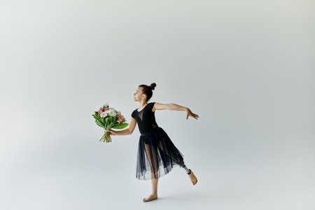 A young gymnast with a prosthetic leg performs a graceful pose while holding a bouquet of flowers.の写真素材