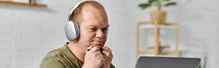 A man with inclusivity wearing headphones sits at home, lost in thought.