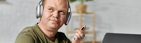 A man with inclusivity relaxes at home, wearing headphones and casual clothing.