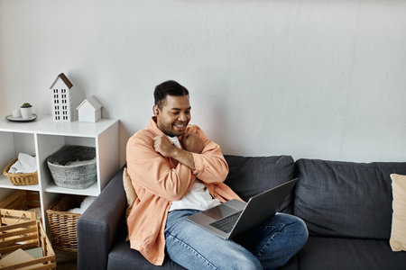An African American man sitting on a couch, smiling and communicating using sign language.の写真素材