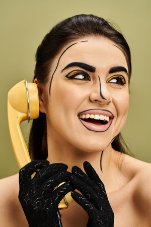 Stylish brunette in pop art makeup, holding phone to her face, embodying modern communication and...