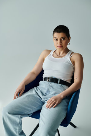 A young woman with short hair sits elegantly in a chair in a relaxed and composed posture.の写真素材