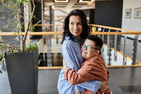 A mother and son with Down syndrome share a loving embrace in a shopping mall.の写真素材