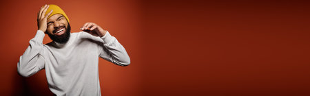 Handsome African American man in fashionable attire poses against vibrant backdrop.