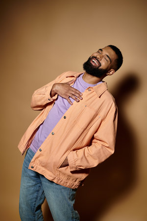 Stylish African American man with beard standing confidently in front of colorful wall