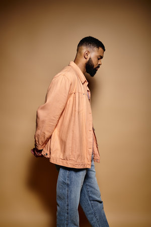 Handsome African American man in fashionable attire standing confidently against a vibrant wall.