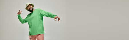 Handsome man in fashionable attire posing on vibrant backdrop.の写真素材