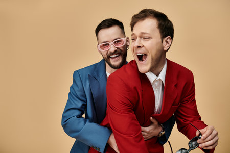 Two men in dapper suits laugh together in a portrait.の写真素材