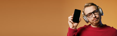 Stylish man listening to music on headphones while scrolling through his cell phone.