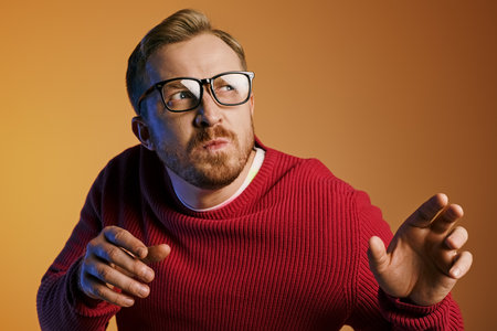 A man posing confidently in a red sweater and glasses.の写真素材