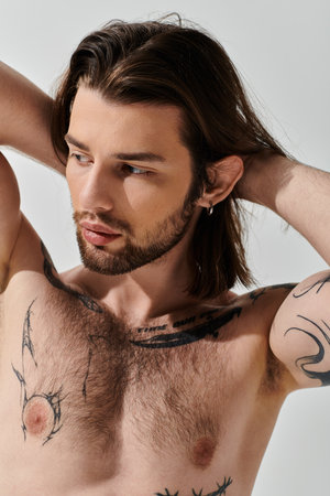 Handsome Caucasian man with long hair and chest tattoos.の写真素材