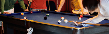 Friends gather around a pool table, enjoying a casual game of billiards.