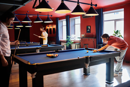 Friends enjoying a game of billiards in a dimly lit bar.
