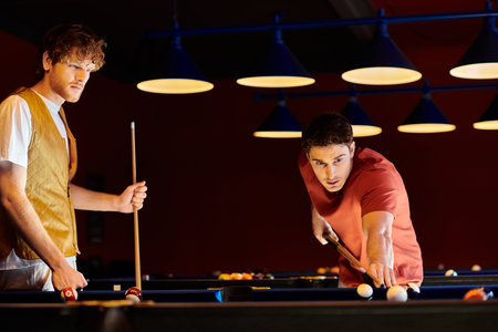 Friends play billiards in a dimly lit room.