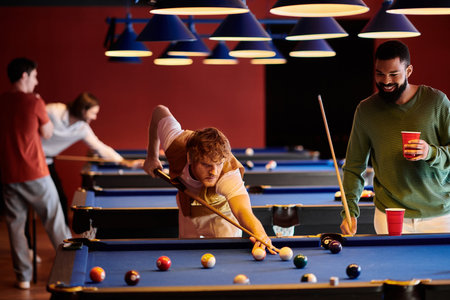 A group of friends play pool in a stylish, contemporary setting.の写真素材