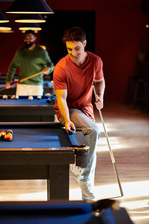 Friends play billiards in a well-lit room, showcasing their relaxed and stylish attire.の写真素材