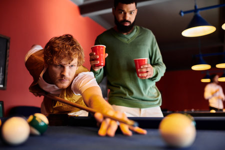 Friends enjoy a game of billiards at a casual establishment.の写真素材