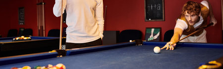 Friends enjoy a casual game of billiards in a stylish setting.の写真素材